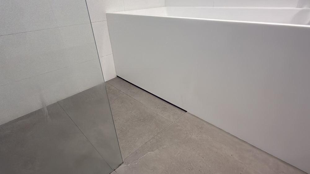 Joint filler between shower floor and bath forming a path for water, found during a defect investigation inspection in Pascoe Vale